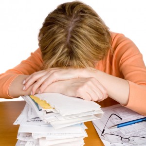 A woman exhausted with tax return form. a stack of bills by her side. Extracted. White background.